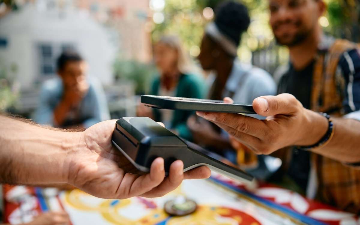 Customer making an instant mobile payment with a smartphone at a point-of-sale terminal.